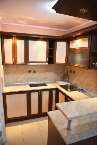 a kitchen with wooden cabinets and a sink at Ивелия Къща за гости in Dospat