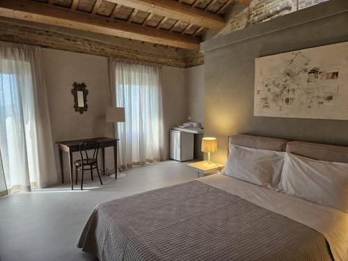 a bedroom with a bed and a desk and a table at Piccola Dimora Gherardini in SantʼElpidio a Mare