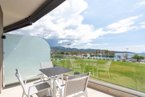a balcony with a table and chairs and a view of the water at Thetis Boutique Apartments in Neos Marmaras