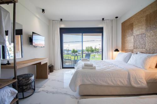 a bedroom with a large bed and a large window at Thetis Boutique Apartments in Neos Marmaras