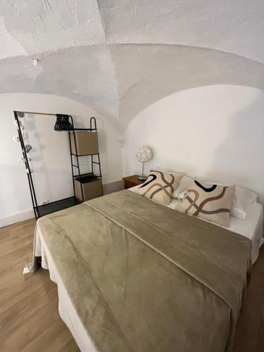 une chambre avec un grand lit dans une pièce blanche dans l'établissement Citadelle de Bastia, à Bastia