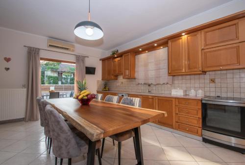 a kitchen with wooden cabinets and a wooden table at Kozanos Hotel & Suites in Amoudi