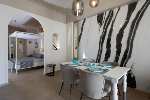 a dining room with a table and chairs and a bedroom at Blue Sea Hotel in Kamari