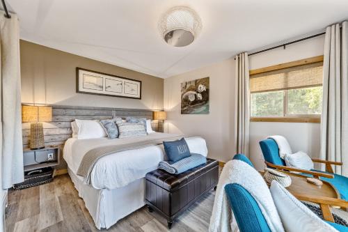 um quarto com uma cama e uma cadeira em The River View House em Gold Beach