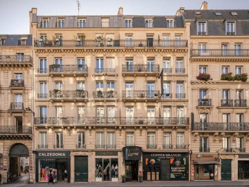 un grand bâtiment en face d'une rue dans l'établissement Legend Hôtel Paris, à Paris