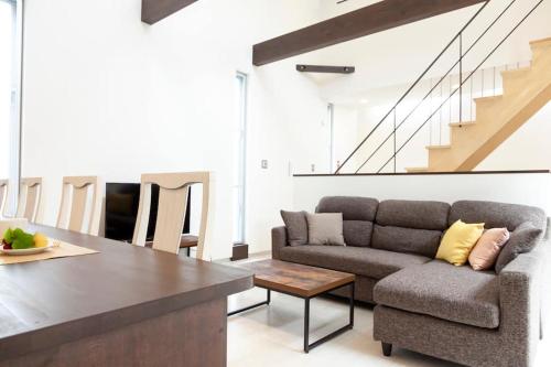 a living room with a couch and a table at ALBREGO-PINO in Naha