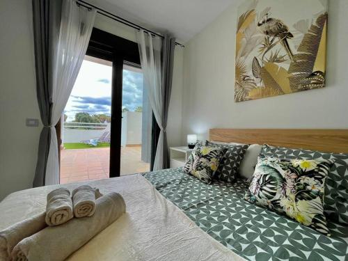 a bedroom with a bed with pillows and a window at Casa Mae in Caleta De Fuste