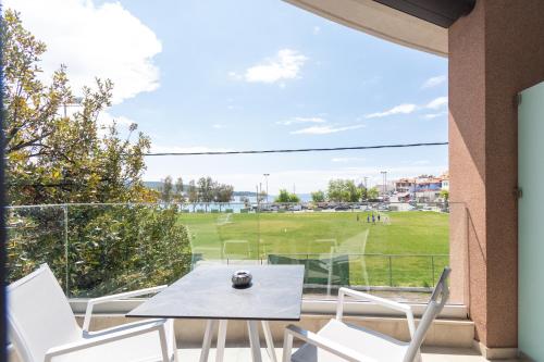 a patio with a table and chairs and a baseball field at Thetis Boutique Apartments in Neos Marmaras
