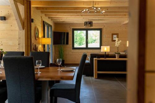 une salle à manger avec une table et des chaises en bois dans l'établissement Chalet au coeur du Jura à 5min de la plage de Clairvaux, à Crillat