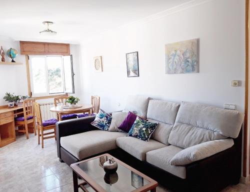 a living room with a couch and a table at Apartamento con vistas al mar en la playa de Vilagarcia - O Feitizo in Vilagarcia de Arousa