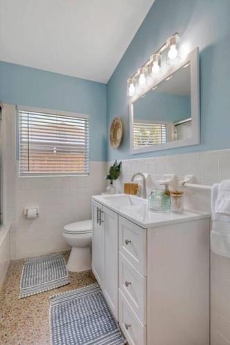 a bathroom with a sink and a toilet and a mirror at *NEW* The Surf Shack Jupiter! in Tequesta