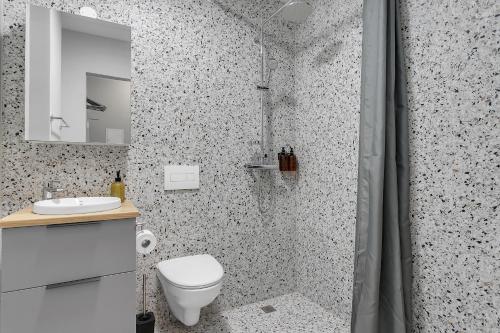 a bathroom with a shower with a toilet and a sink at Cozy Studio Apartment in Reykjavík