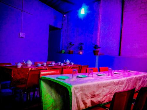 a dining room with purple and green lights at m.i. guest house in Bikaner