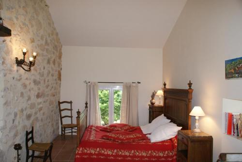 um quarto com uma cama vermelha e uma janela em Chez Bacchus em Gras