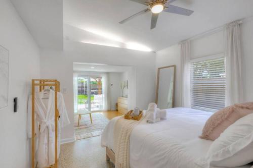 a white bedroom with a bed and a ceiling fan at *NEW* The Surf Shack Jupiter! in Tequesta