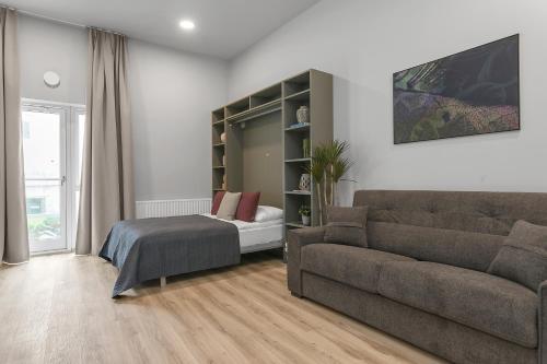 a living room with a couch and a bed at Cozy Studio Apartment in Reykjavík