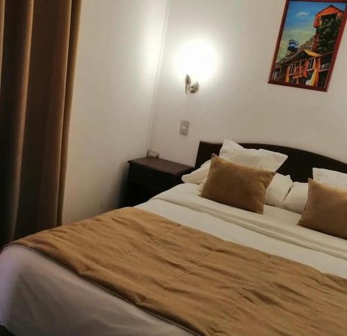a bedroom with a large bed with brown pillows at Pueblo Andaluz Olmué in Olmué