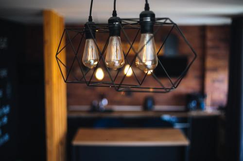 a cluster of lights hanging over a table at Apartman PAOLA in Slavonski Brod