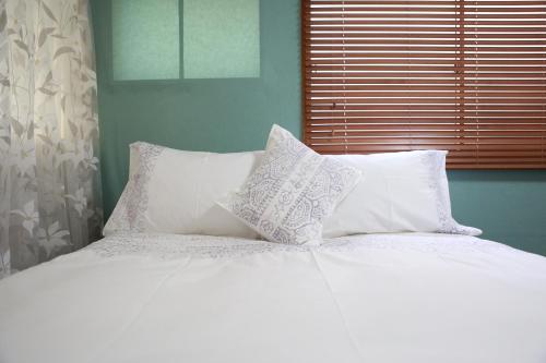 a white bed with four pillows and a window at Ueno上野!Akihabara秋葉原!Asakusa 浅草!3min walk to station!交通便利地点繁华!附近美食!商场百货遍地! 干湿分离! 智能马桶! 高速无限制网路! 高级公寓403 in Tokyo