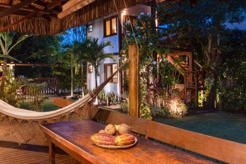a wooden bench with a bowl of bread on it at Aldeia dos Corais - Taipu de Fora in Barra Grande