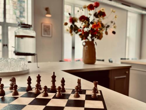 カストリクムにあるHotel het Oude Raadhuisのキッチンカウンターの上に置かれたチェス盤と花瓶
