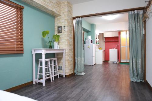 a living room with a table and a refrigerator at Ueno上野!Akihabara秋葉原!Asakusa 浅草!3min walk to station!交通便利地点繁华!附近美食!商场百货遍地! 干湿分离! 智能马桶! 高速无限制网路! 高级公寓403 in Tokyo