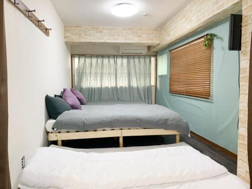a bedroom with two beds and a window at Ueno上野!Akihabara秋葉原!Asakusa 浅草!3min walk to station!交通便利地点繁华!附近美食!商场百货遍地! 干湿分离! 智能马桶! 高速无限制网路! 高级公寓403 in Tokyo