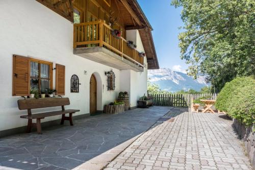 a porch of a house with a bench and a balcony at Weingartnerhof Dalia in San Genesio Atesino