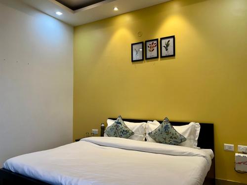 a bedroom with a bed with three pictures on the wall at Daisy by Wabi Sabi Stays with Private balcony in Rishīkesh