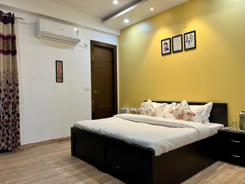 a bedroom with a large bed with a yellow wall at Daisy by Wabi Sabi Stays with Private balcony in Rishīkesh