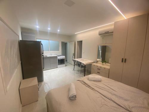 Dieses weiße Zimmer verfügt über ein Bett und eine Küche. in der Unterkunft דירת בוטיק - Boutique apartment in Bayit Wegan