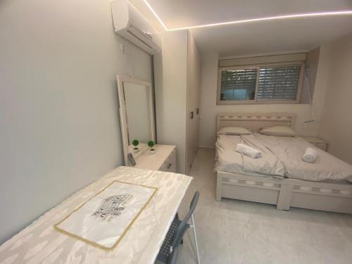 Bayit Weganにあるדירת בוטיק - Boutique apartmentのベッドとテーブルのある小さな寝室
