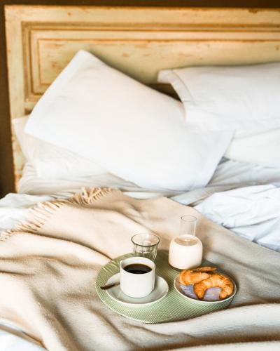a breakfast tray with coffee and pastries on a bed at Casa Lila in Mendoza