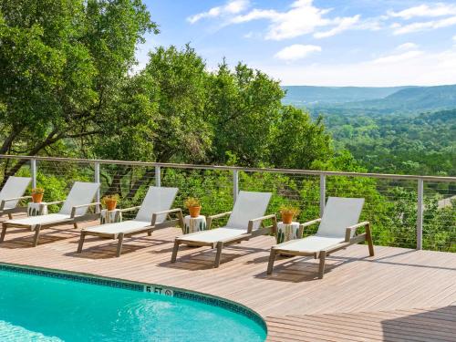 a deck with chairs and a pool with a view at The Bygone in Wimberley