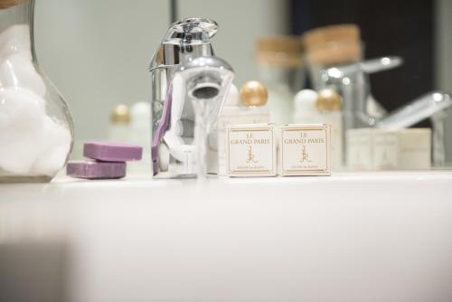 a bathroom counter with a faucet and a sink at Le Grand Paris in Digne-les-Bains