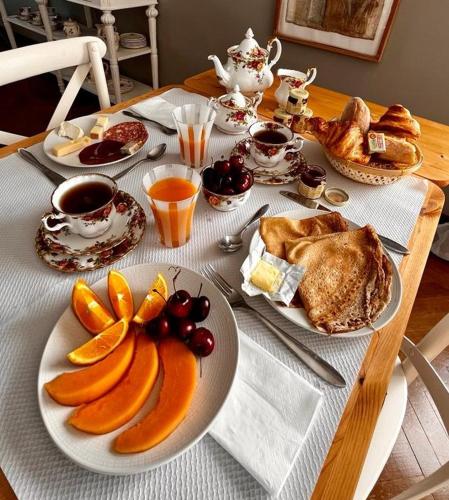 - une table avec des assiettes de nourriture et des fruits dans l'établissement Un B&B à Loktudi, à Loctudy