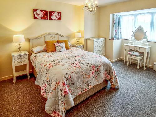 a bedroom with a bed and two tables and a window at Littlecot in Wyke Regis