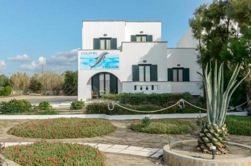 a white building with a dolphin sign in front of it at Dolphin Studios in Agia Anna Naxos