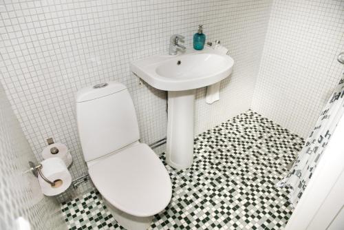 uma casa de banho branca com um WC e um lavatório em Johannas GuestHouse em Söderköping