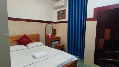 a bedroom with a bed and a blue curtain at Hoàng Anh Hotel in Ho Chi Minh City