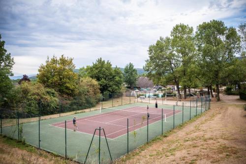 einen Tennisplatz, auf dem die Leute spielen in der Unterkunft HUTTOPIA Divonne in Divonne-les-Bains
