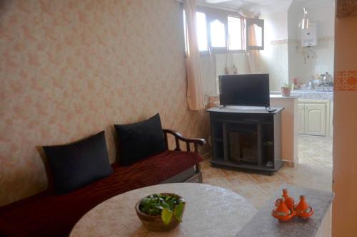 a living room with a red couch and a television at Private appartement in the centre of Taghazout in Taghazout