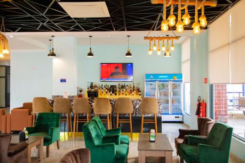 a restaurant with green chairs and a bar at Best Western Dodoma City Hotel in Dodoma