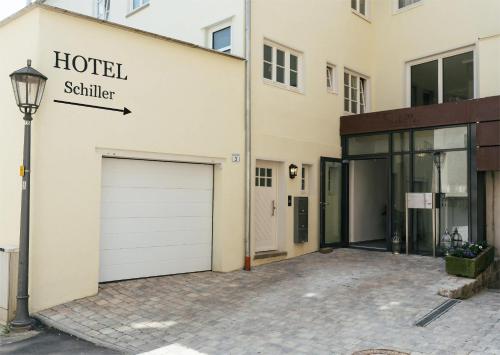 a parking lot in front of a hotel sittier building at Hotel Schiller in Bietigheim-Bissingen