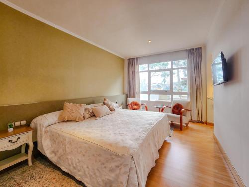 a bedroom with a large bed and a television at Hotel Faranda Rías Altas in Perillo