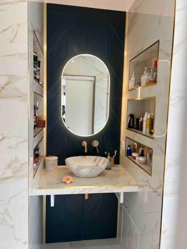une salle de bain avec un lavabo et un miroir dans l'établissement Villa piscine à débordement, à Pignan