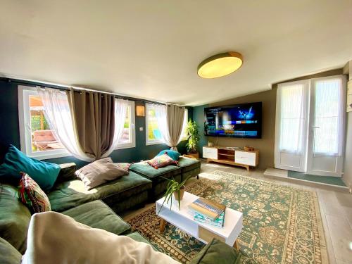 un soggiorno con divano e TV di BAOBAMBOU à 5 min de l'Océan a Vielle-Saint-Girons