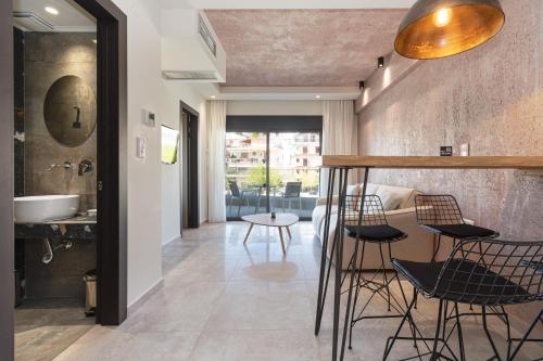 a room with a bar with chairs and a sink at Thetis Boutique Apartments in Neos Marmaras