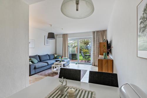 a kitchen and living room with a blue couch at Gartenglückchen in Lindhöft