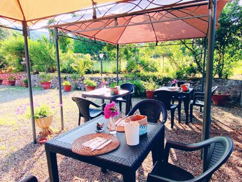 a patio with tables and chairs under an umbrella at Villa Gaia in Portoferraio
